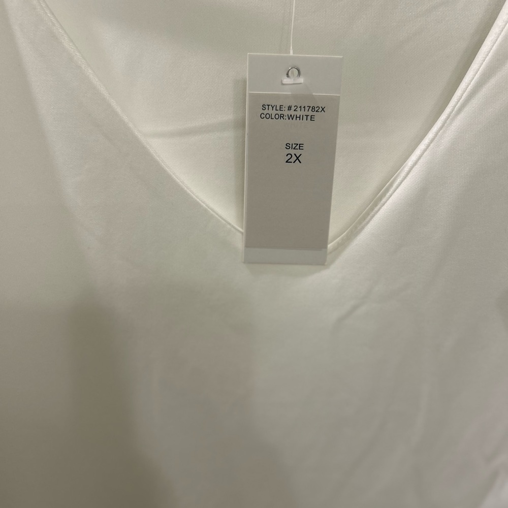 White size 2x with gorgeous ruffle sleeves.  Stretchy fabric.  NWT